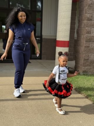 Miracle is dressed in scrub after her little child who has a stethoscope