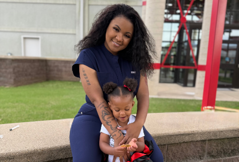 Miracle is dressed in sheds and cradles her toddler